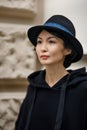 A girl of Asian appearance in a black blouse and hat