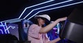 Asian girl in virtual reality glasses drives a car in 5D