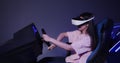 Asian girl in virtual reality glasses drives a car in 5D