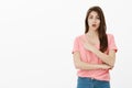 Girl asking advice while pointing at dress she wants to buy. Portrait of good-looking busy young woman in casual outfit Royalty Free Stock Photo