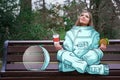 A girl in an astronaut costume arrived on earth to rest and eat fast food. Drawing on top of the photo