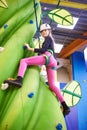 Girl athlete climbing on artifical green tree