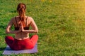 Girl athlete does a namaste pose from behind. young female body arms on sunset background outdoors Royalty Free Stock Photo