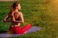 Girl athlete does a namaste pose from behind. young female body arms on sunset background outdoors Royalty Free Stock Photo