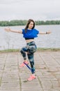 Girl athlete does squats in nature exercises for the buttocks. Young woman go in for sports healthy lifestyle athletic body.