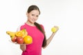 Girl athlete holding a plate of fruit and dumbbell Royalty Free Stock Photo