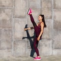 Girl athlete performs a warm-up before training on the street near the wall