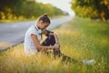 Girl athlete resting sitting on the grass by the road in training Royalty Free Stock Photo