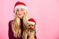 Girl attractive blonde hold dog pet pink background. Woman with puppy wear santa hat. Celebrate christmas with pets
