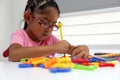 Girl with autism spectrum disorder ASD like Asperger, Rett and Heller draws at a desk, plays with colors alone antisocial