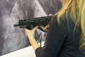 Girl with an automatic rifle in the hands of the counter. Weapon Royalty Free Stock Photo