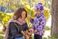 girl with autumn leaves with her mother believes gathered acorns in the park