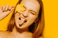 Girl with autumn leaves and red makeup, grimaces and has fun. Autumn photo on yellow background Royalty Free Stock Photo