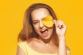 Girl with autumn leaves and red makeup, grimaces and has fun. Autumn photo on yellow background Royalty Free Stock Photo