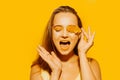 Girl with autumn leaves and red makeup, grimaces and has fun. Autumn photo on yellow background Royalty Free Stock Photo