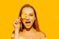 Girl with autumn leaves and red makeup, grimaces and has fun. Autumn photo on yellow background Royalty Free Stock Photo