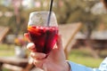 A girl in an autumn raincoat drinks sangria an open-air cafe Royalty Free Stock Photo