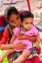 Girl with a baby girl sitting in the street in Taj Ganj neighbor