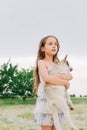 Girl with baby goat on farm outdoors. Love and care. Village animals. happy child hugs goat, concept of unity of nature Royalty Free Stock Photo