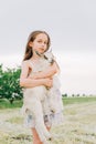 Girl with baby goat on farm outdoors. Love and care. Village animals. happy child hugs goat, concept of unity of nature Royalty Free Stock Photo