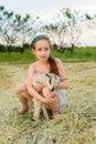 Girl with baby goat on farm outdoors. Village animals. happy child hugs goat, concept of unity of nature and man Royalty Free Stock Photo