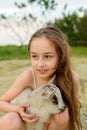 Girl with baby goat on farm outdoors. Village animals. happy child hugs goat, concept of unity of nature and man Royalty Free Stock Photo