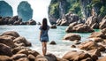 Girl back looking at the high rocks at the sea Royalty Free Stock Photo