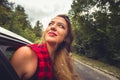 Girl on the back seat in the car with her head of the window