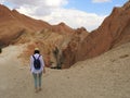 Girl, back view, face not visible goes to mountain oasis of Chebika with palm trees in sandy Sahara desert, blue sky, Tunisia, Royalty Free Stock Photo