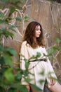 girl on a background of a brick wall with tree leaves. a combination of nature and construction. alive and not alive.