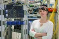 The girl is on a background of powerful data center datacenters. Portrait of a woman working as a system administrator in an