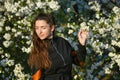 Girl on a background of a white flowering tree. Outdoor portrait of young beautiful fashionable elegant lady with long hair, Royalty Free Stock Photo