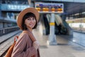 Girl with a backpack. beautiful and young girl in a hat at the station. A young woman in a coat and hat stands on the station Royalty Free Stock Photo