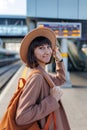 Girl with a backpack. beautiful and young girl in a hat at the station. A young woman in a coat and hat stands on the station Royalty Free Stock Photo