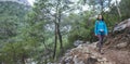 A girl with a backpack goes along a mountain trail Royalty Free Stock Photo