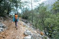 A girl with a backpack goes along a mountain trail Royalty Free Stock Photo