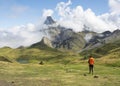 Girl with backpack hiking, Midi d?Ossau peak in the background in the Pyrenees National Park.