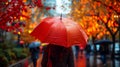 Girl with backpack holding bright umbrella, walking under the rain along the street of the city. Autumn rainy day. Royalty Free Stock Photo