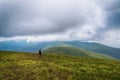 Girl with a backpack in the mountains. Low clouds. Fog. Solitude with nature. Loneliness. Freedom. Tourism.