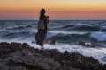 A girl with a backpack stands against the sea. A lone traveler admires the sunset Royalty Free Stock Photo