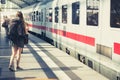 Girl with backpack at train station before entering train