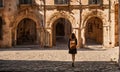 Girl with backpack walking on cobblestone street