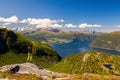 Girl with backpack watching Norwegian fjords in sunny weather, Norway