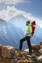 A girl backpacker stands on top of a mountain