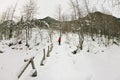 Girl backpacker walking on a bridge over a frozen river in the w Royalty Free Stock Photo