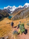 Girl backpackers hiking towards Jahuacocha lakes at Huayhuash circuit, Cordillera Huayhuash, Peru Royalty Free Stock Photo