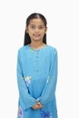 Girl in baju kurung smiling at the camera. Conceptual image