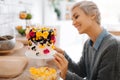 Girl baker decorates cake with edible colors in her kitchen