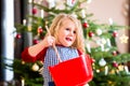 Girl baking cookies in front of Christmas tree Royalty Free Stock Photo