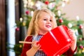 Girl baking cookies in front of Christmas tree Royalty Free Stock Photo